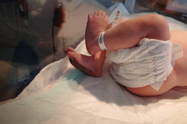 Baby feet in bassinet, black ink on the bottoms.